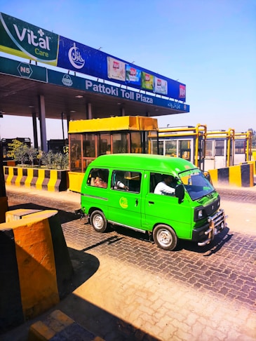 a green van parked in front of a gas station