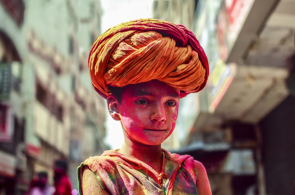 a young boy wearing a red turban on his head