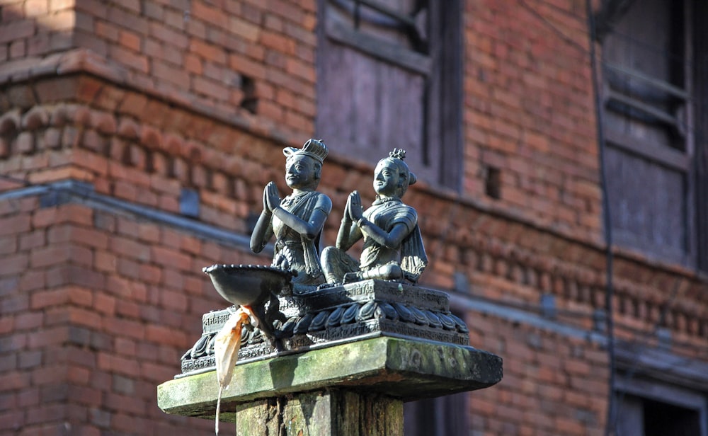a statue of two people sitting on top of a fountain
