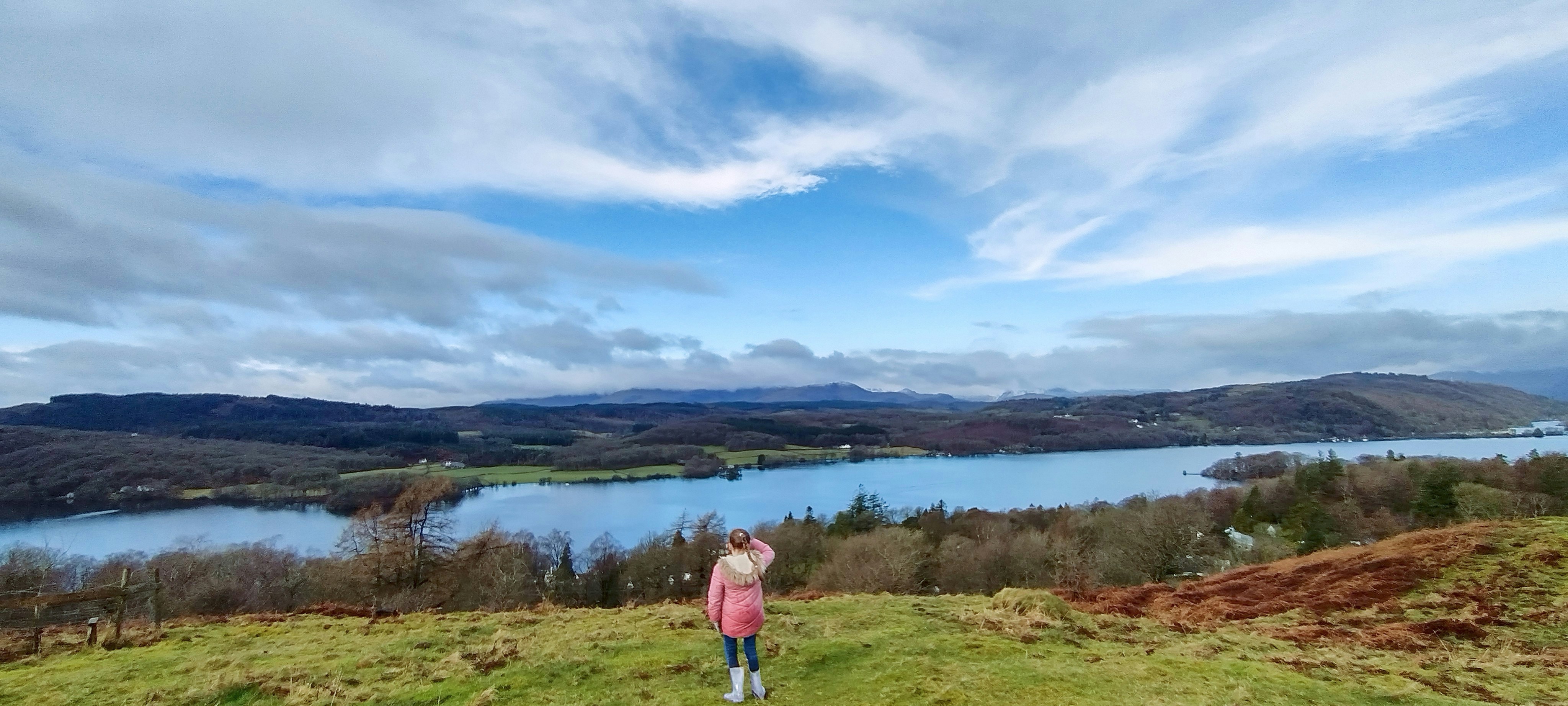 A woman standing on top of a lush green hillside photo – Free ...