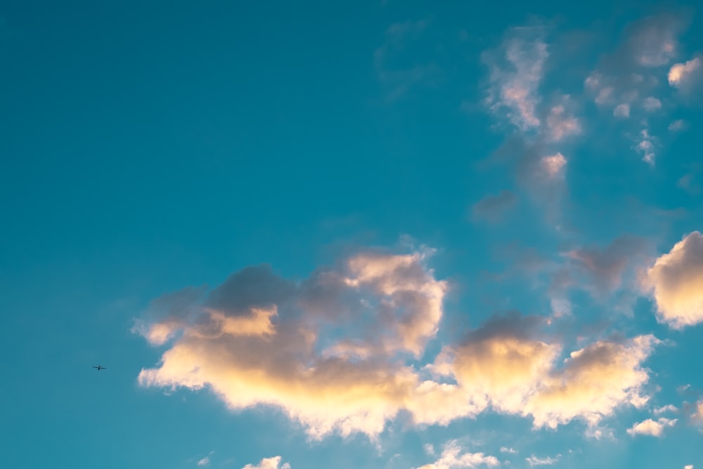 Un aereo che vola attraverso un cielo blu con le nuvole