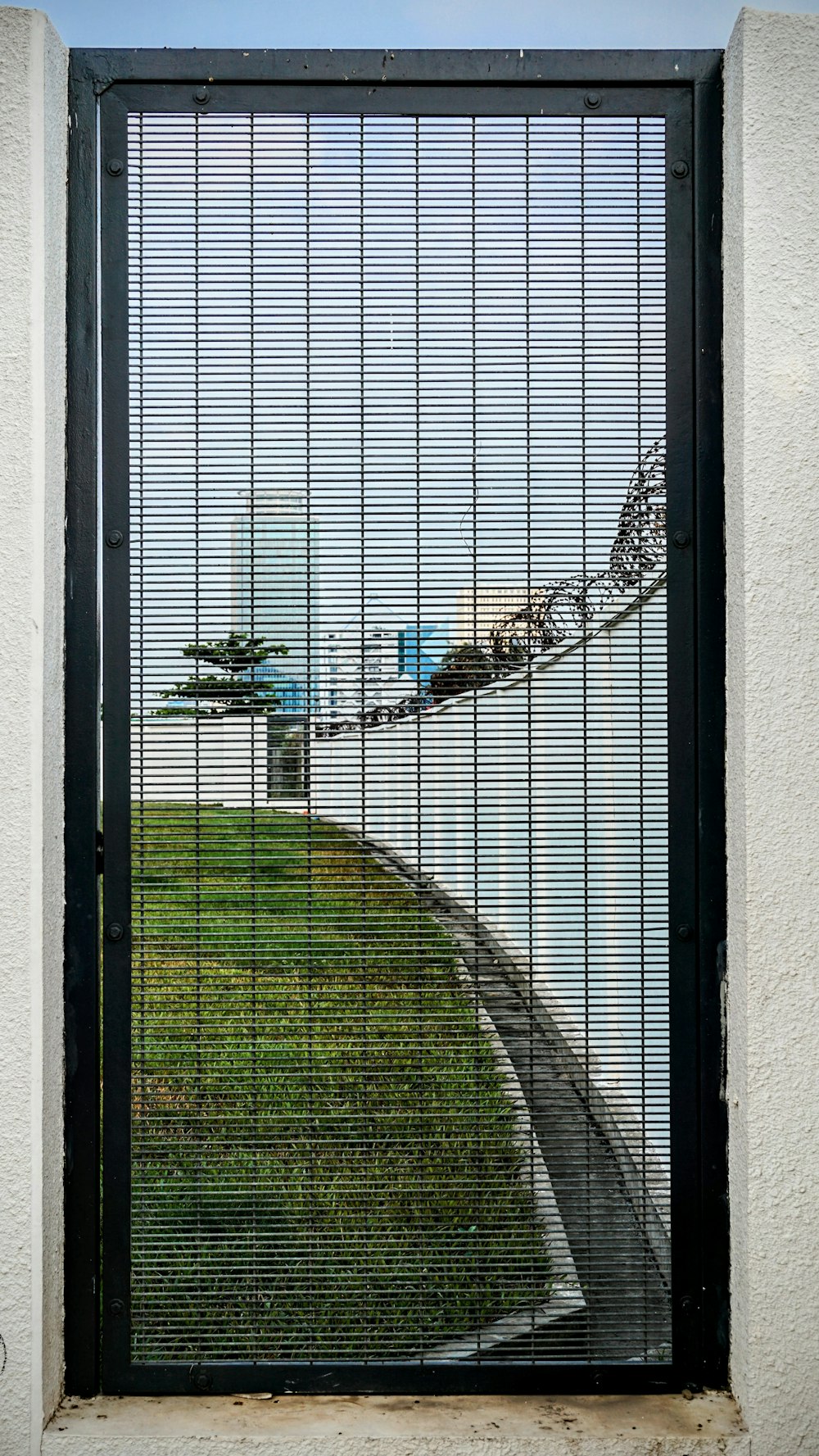 a gate with a view of a grassy area through it
