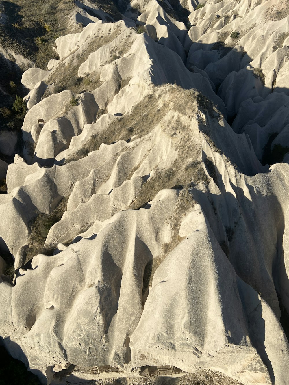 una vista di una catena montuosa con rocce ed erba in primo piano