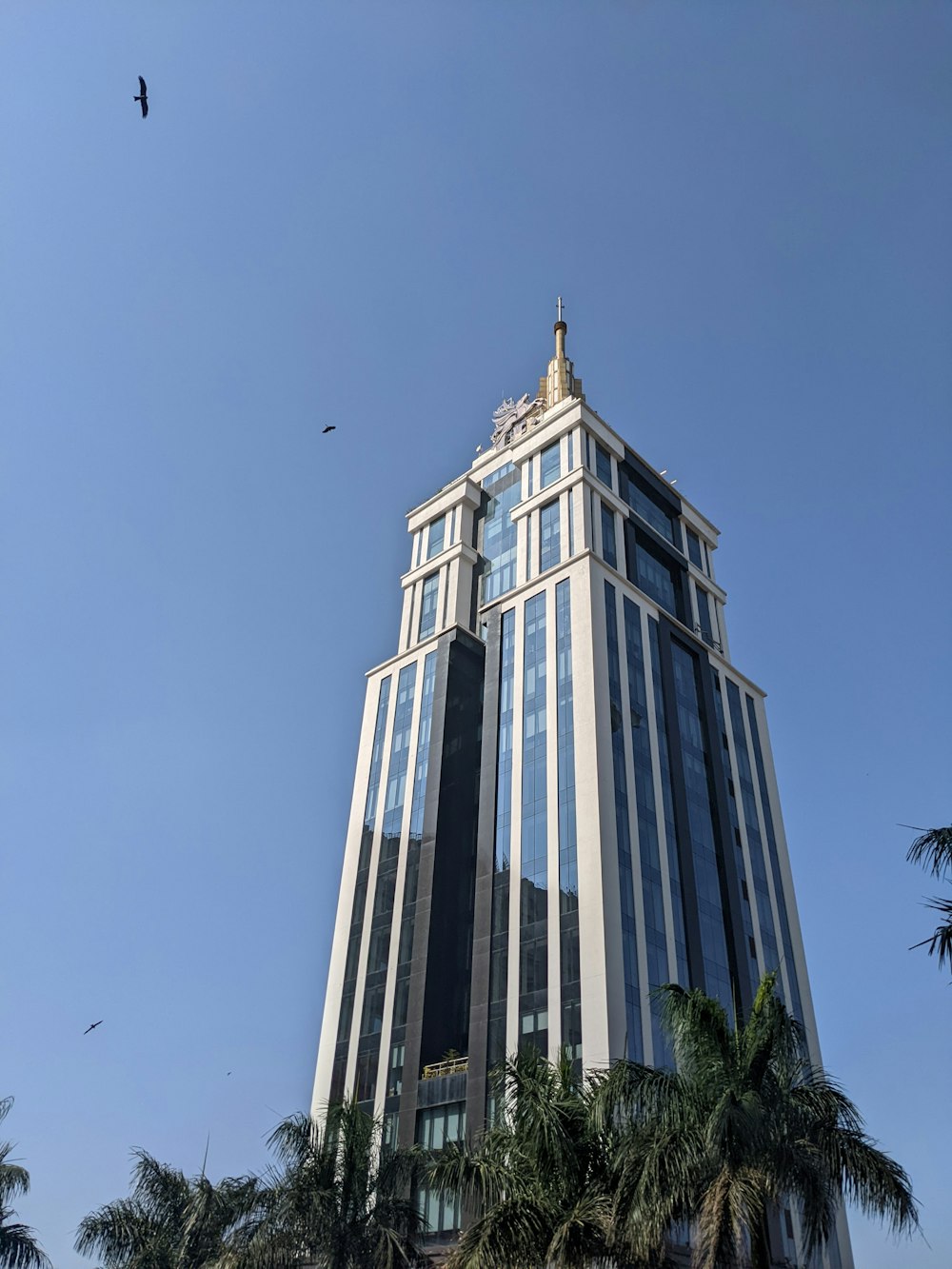 a very tall building with a bird flying in the sky