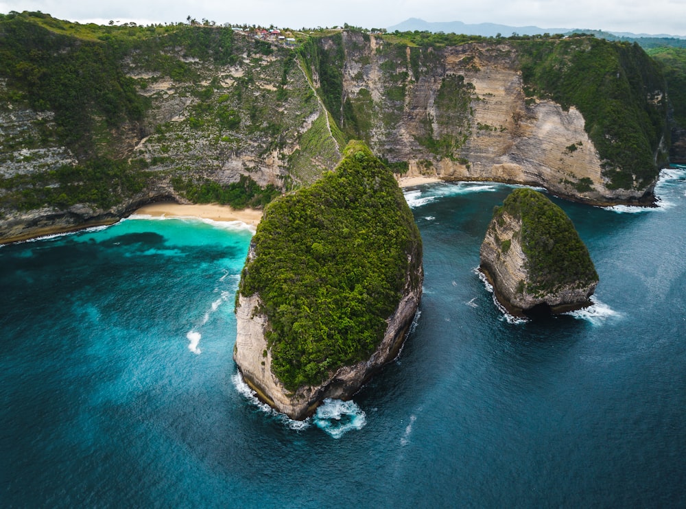 an aerial view of two large rocks in the middle of a body of water