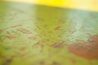 Close-up of a textured oil painting with soft green and beige tones.