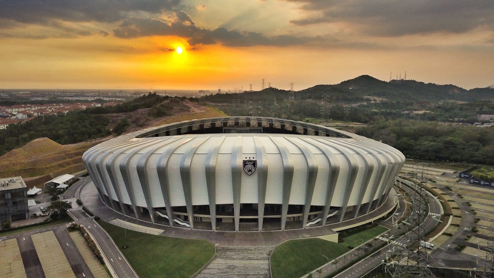 an aerial view of a soccer stadium with a sunset in the background