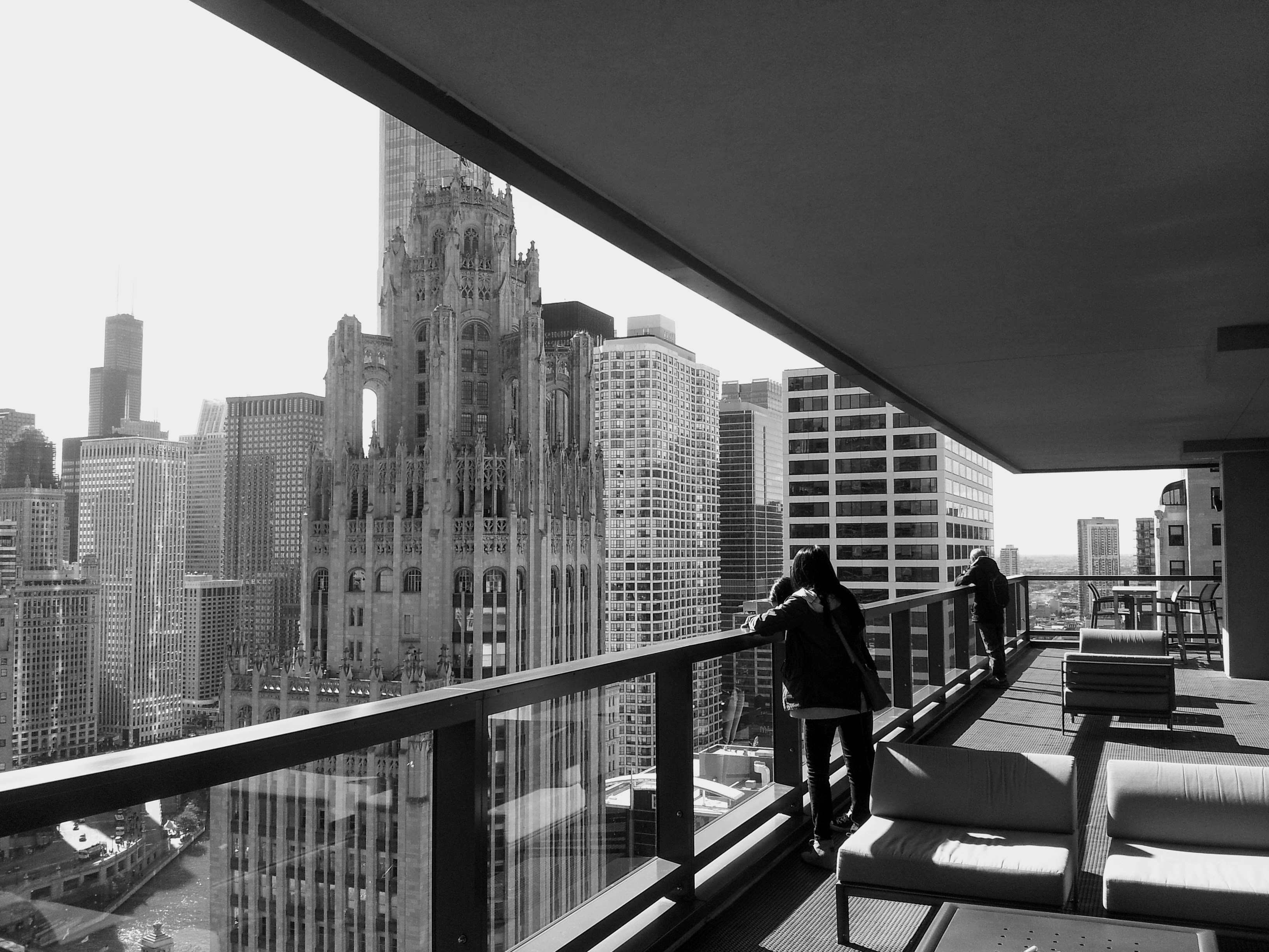 person enjoying coffee on private balcony overlooking busy Chicago morning - city view