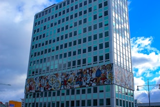A vibrant mural being printed on a large stone surface inside a modern office lobby.