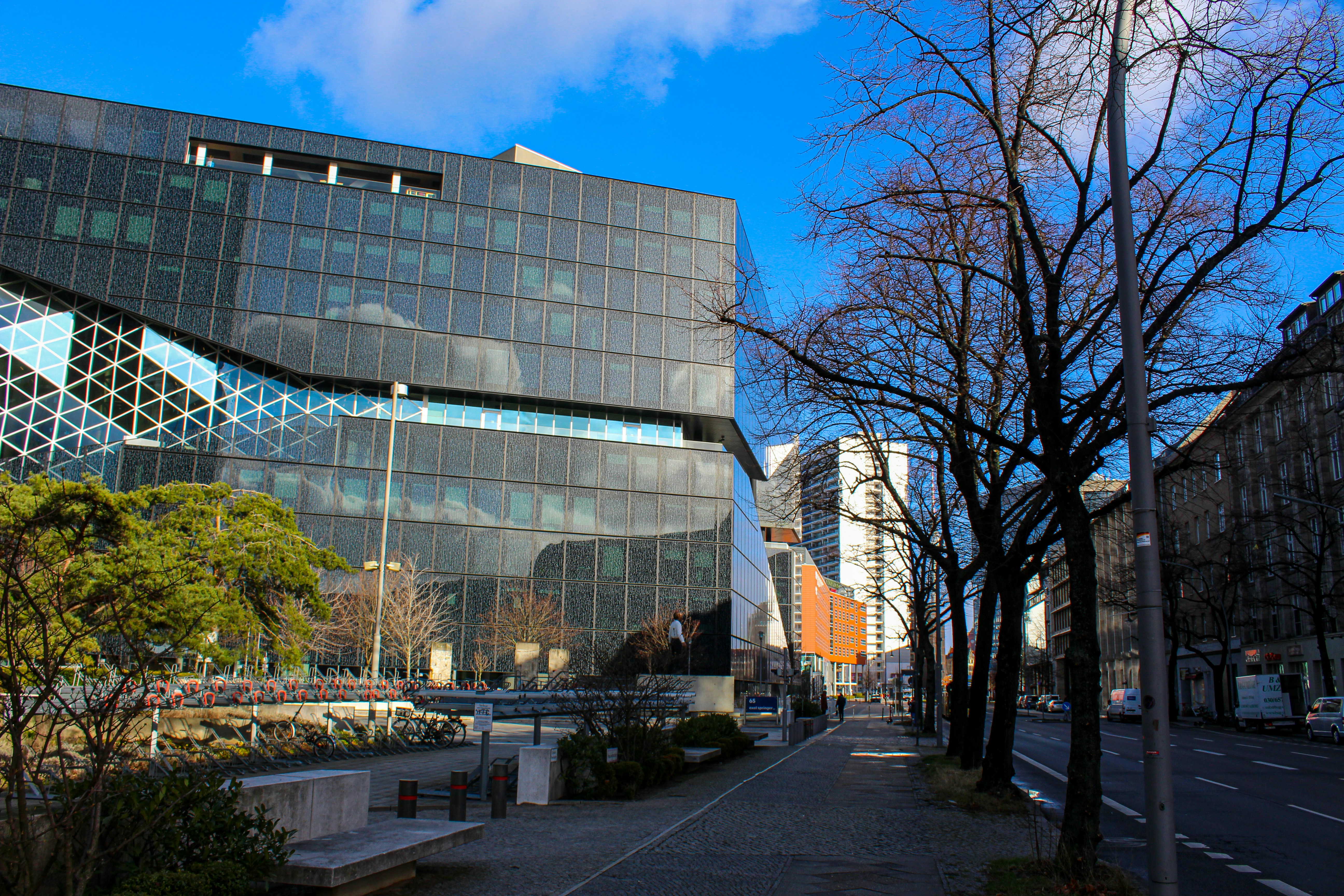 a large glass building sitting on the side of a road