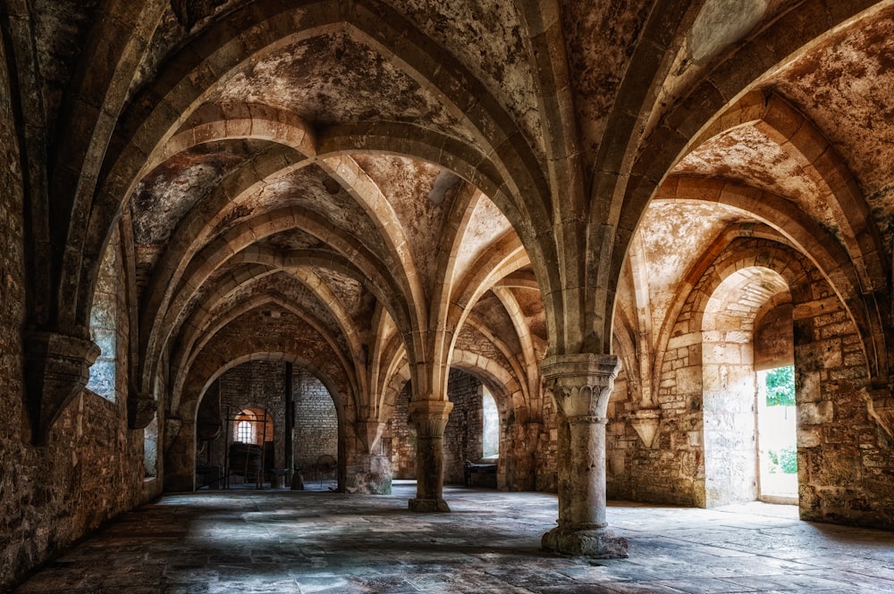 a large room with arches and stone floors