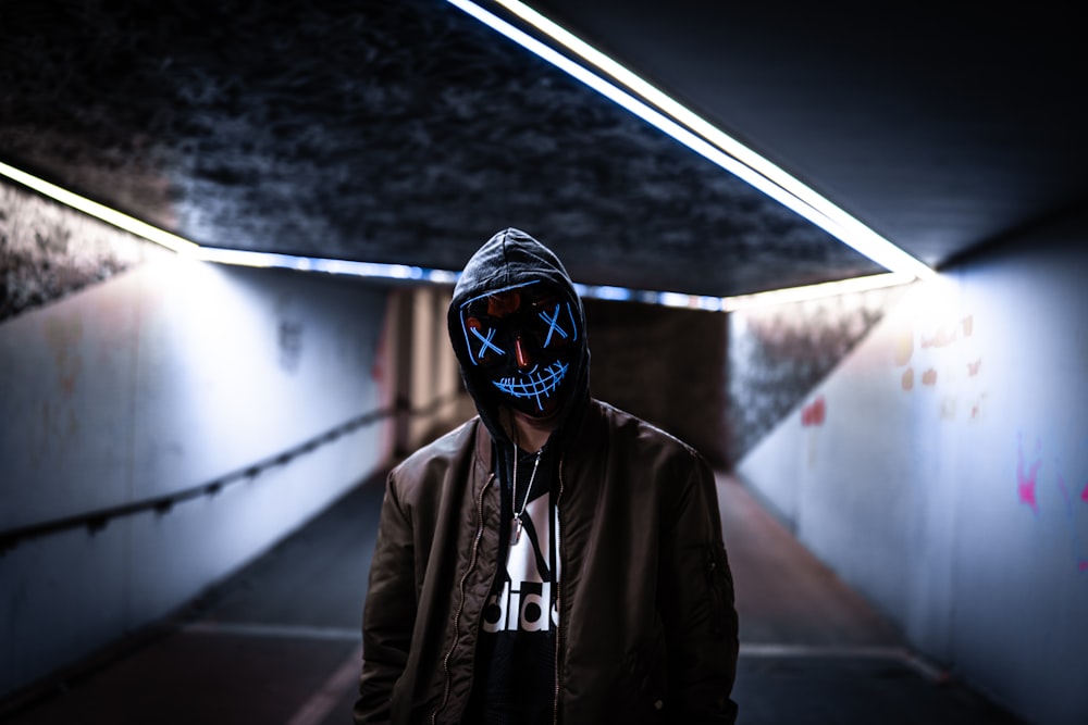 a man wearing a mask in a dark tunnel