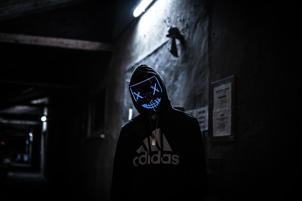 a person wearing a neon mask in the dark