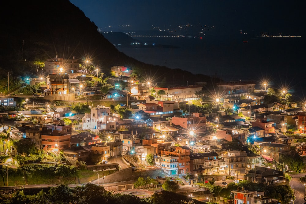 a night time view of a city with a mountain in the background