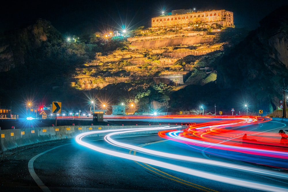 a long exposure photo of a road with a castle on a hill in the background