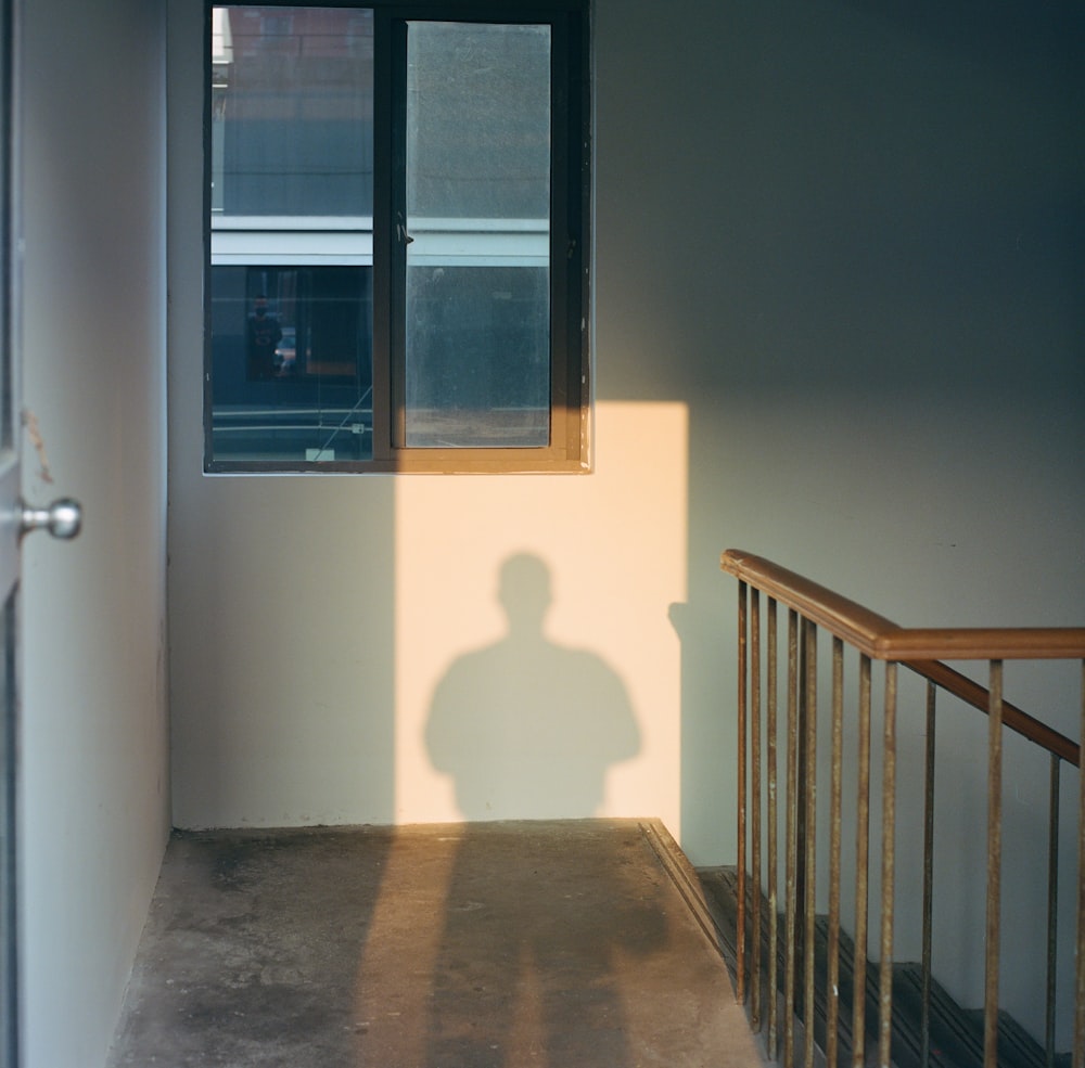 a shadow of a person standing in front of a window