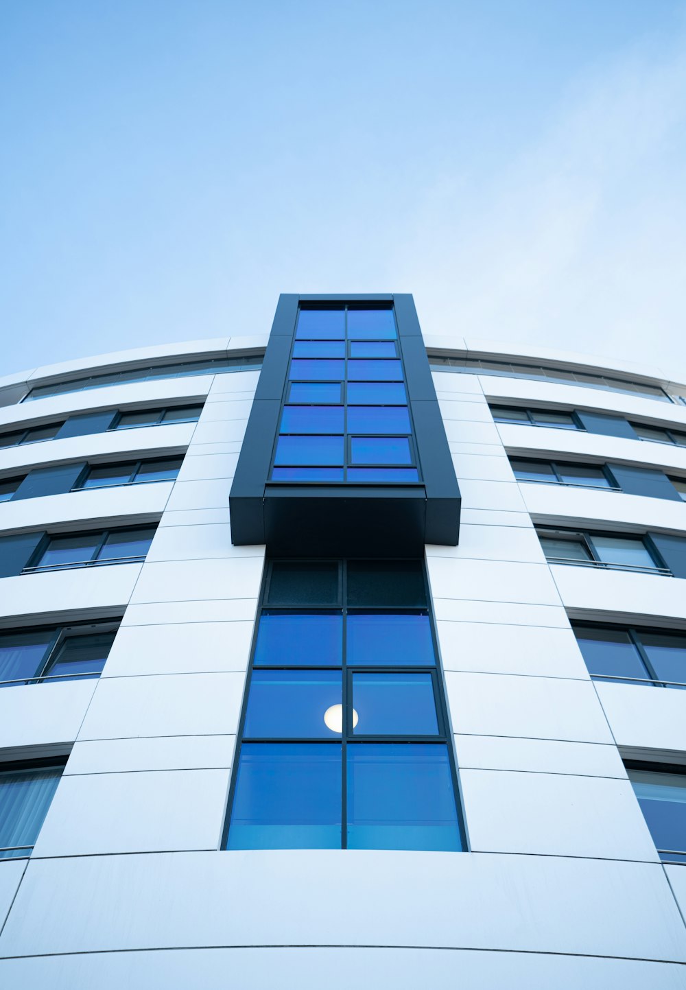 a tall white building with a blue sky in the background