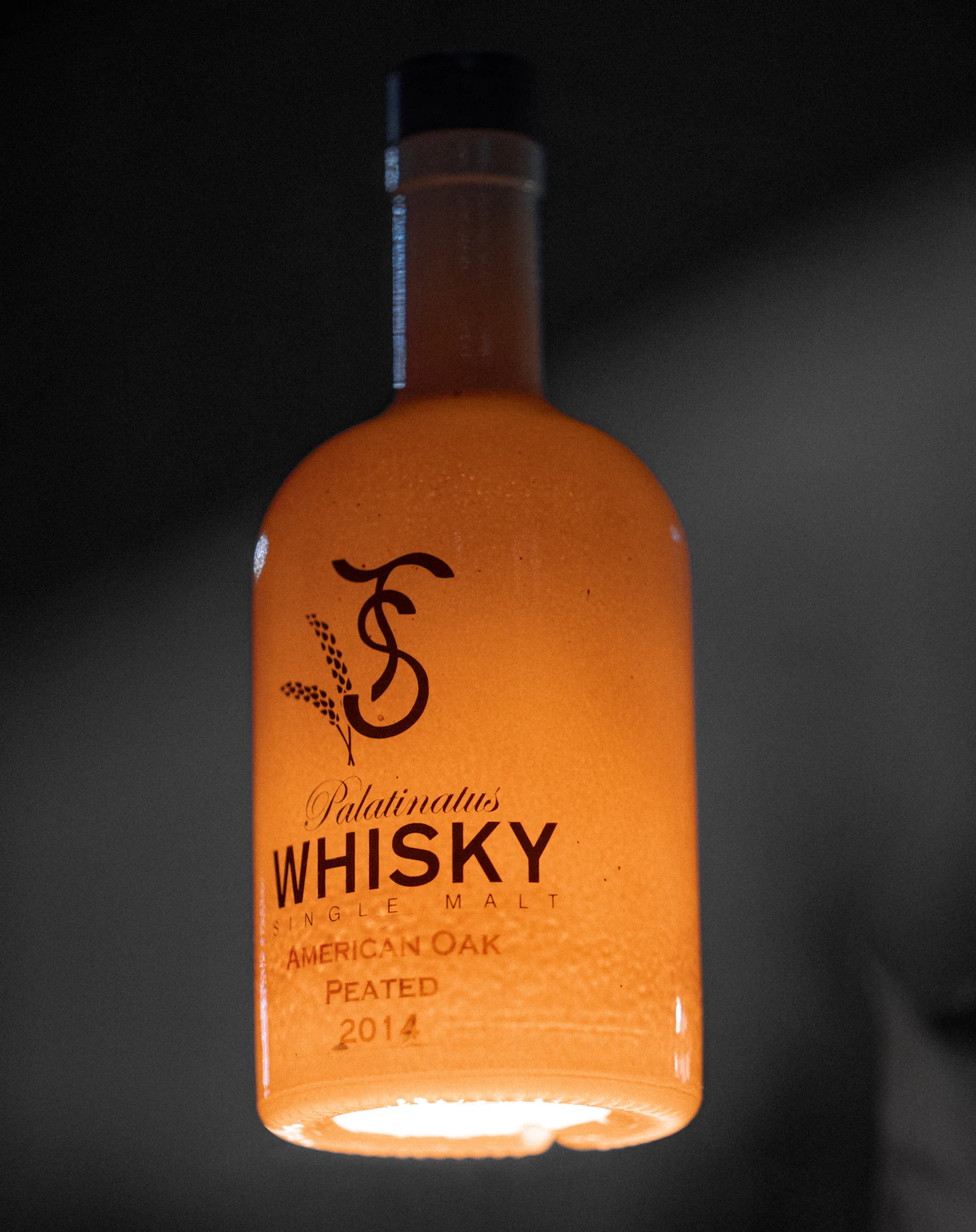 Single malt whisky tumbler beside a dark stone coaster.