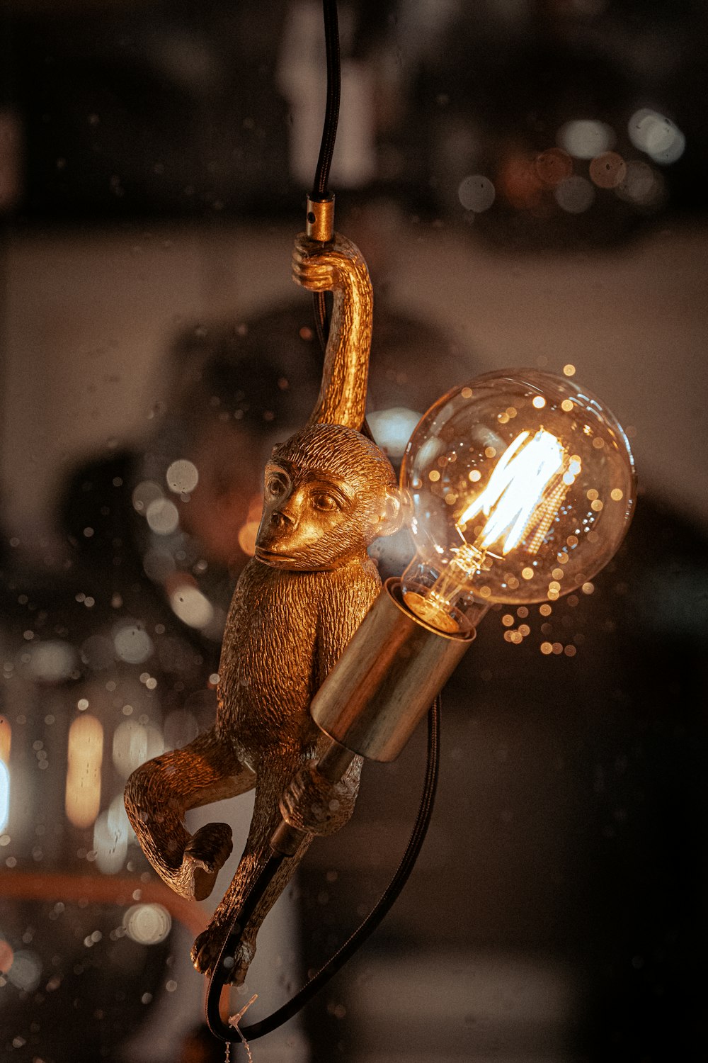a lamp with a monkey hanging from it's side