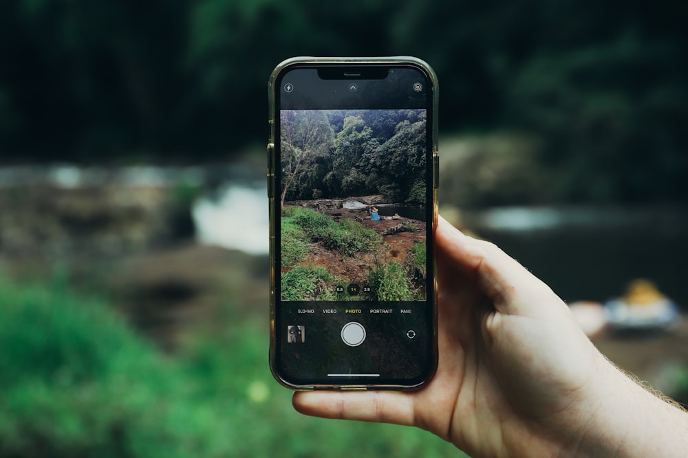 a person holding up a cell phone to take a picture