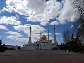 A serene landscape of a mosque under a clear blue sky.