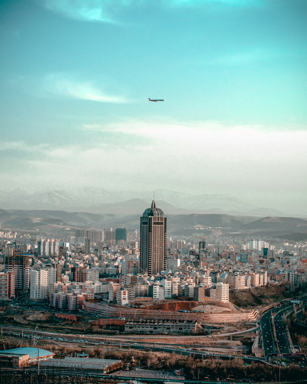 an airplane flying over a city with tall buildings