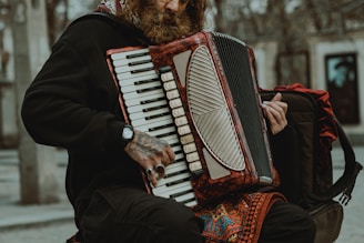 A close-up of hands skillfully playing a 34-button diatonic accordion in a rustic setting.