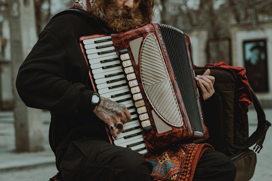 A close-up of hands skillfully playing a 34-button diatonic accordion in a rustic setting.