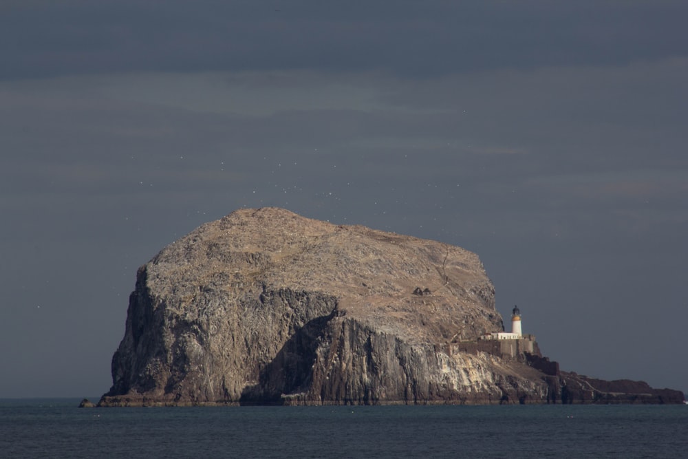 a large rock with a light house on top of it