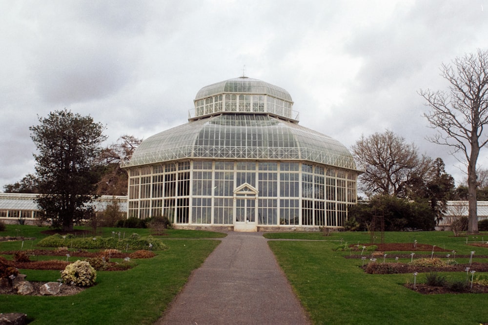 a large glass building with a walkway in front of it