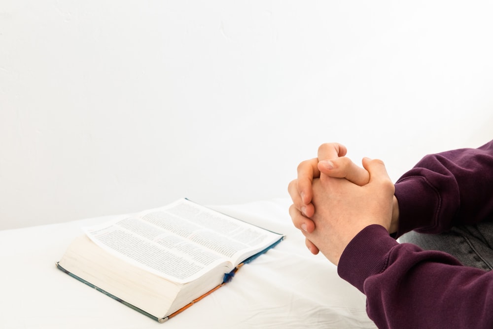 a person sitting at a table with an open book