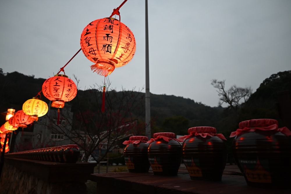 uma fileira de lanternas com escrita chinesa sobre eles