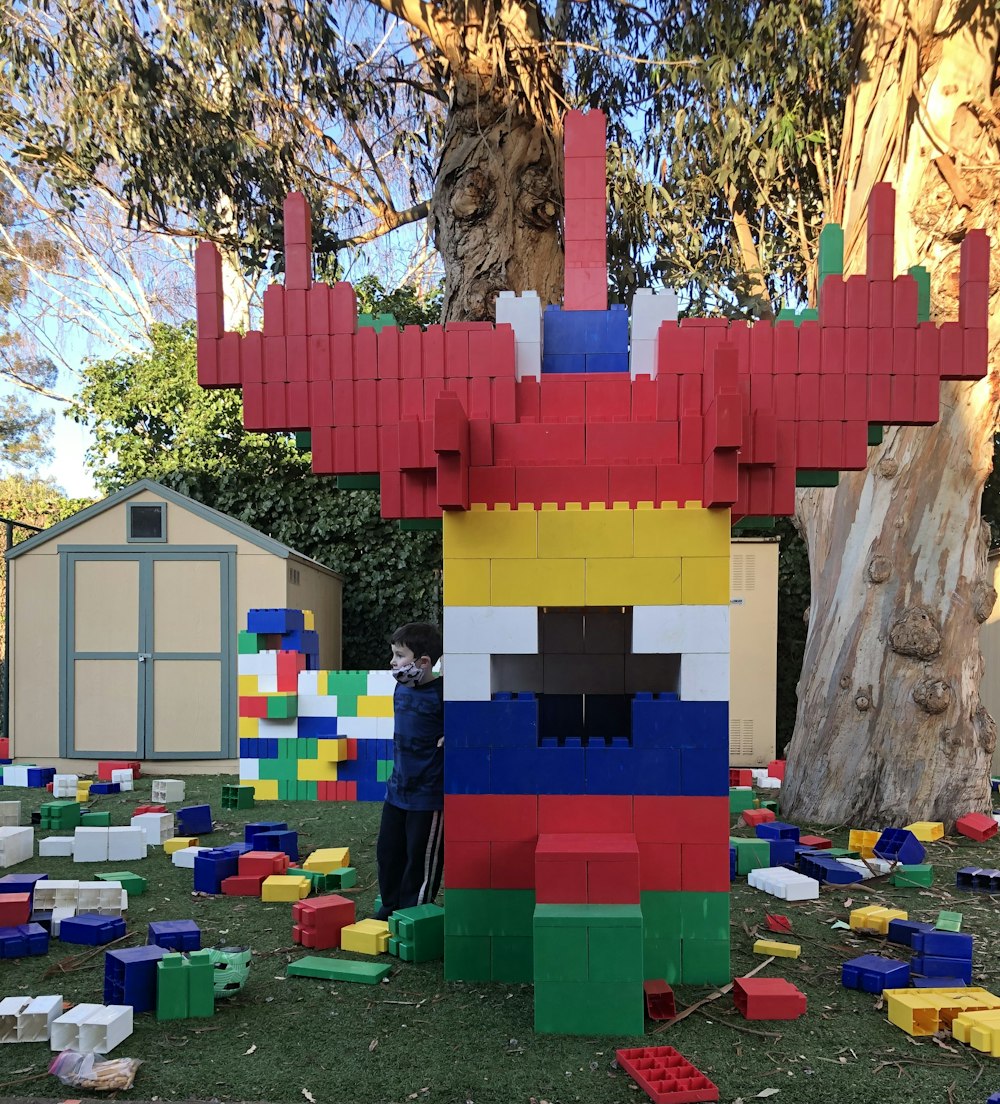 a man standing in front of a building made out of legos