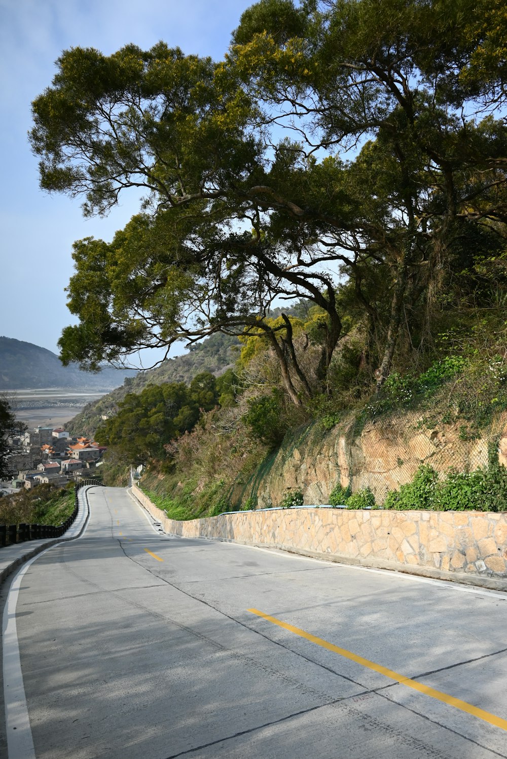 an empty road with trees on the side of it