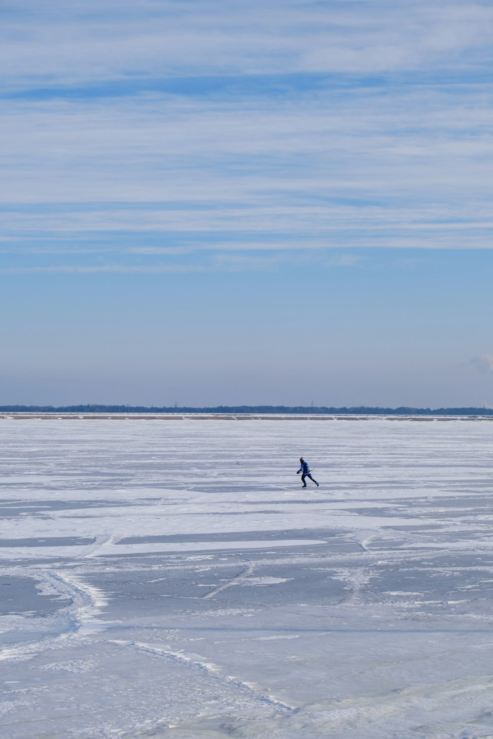 a person walking across a frozen lake on a sunny day