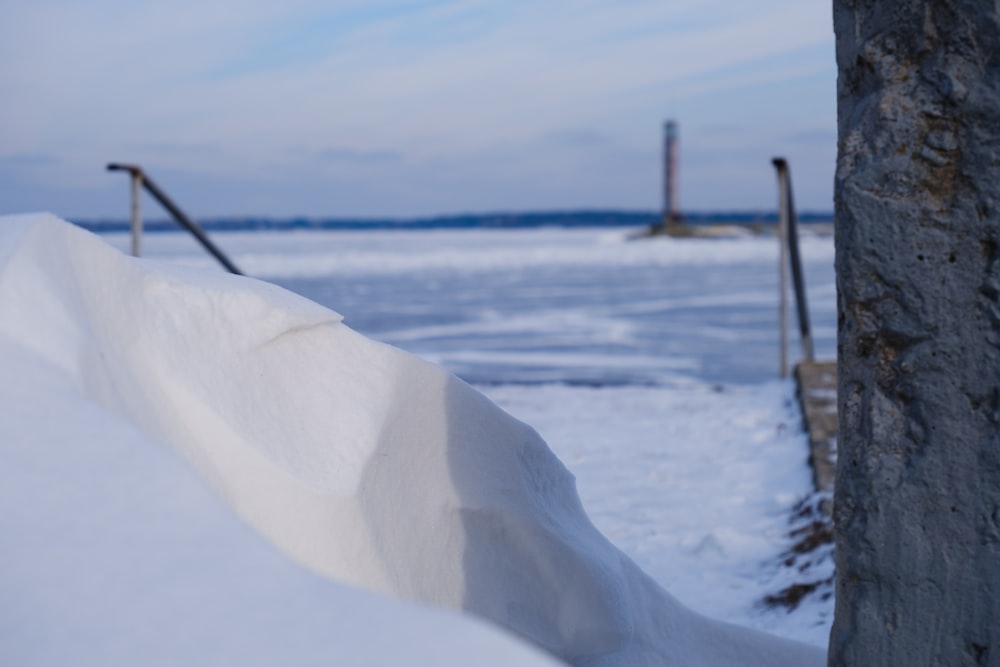 a snow bank with a lighthouse in the background