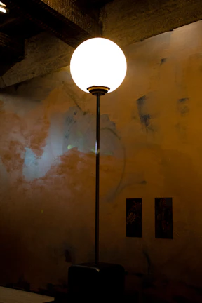 Elegant luminous art piece glowing gently against a dark gray wall, emphasizing texture and form.