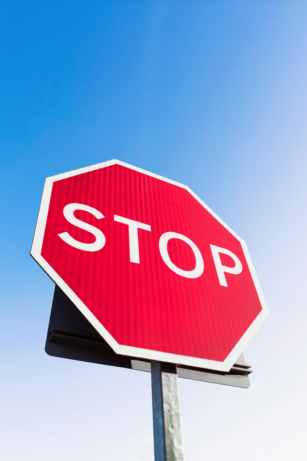 Un segnale di stop con un cielo blu sullo sfondo