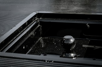 Close-up of a black metal frame freshly coated with smooth, glossy powder finish.