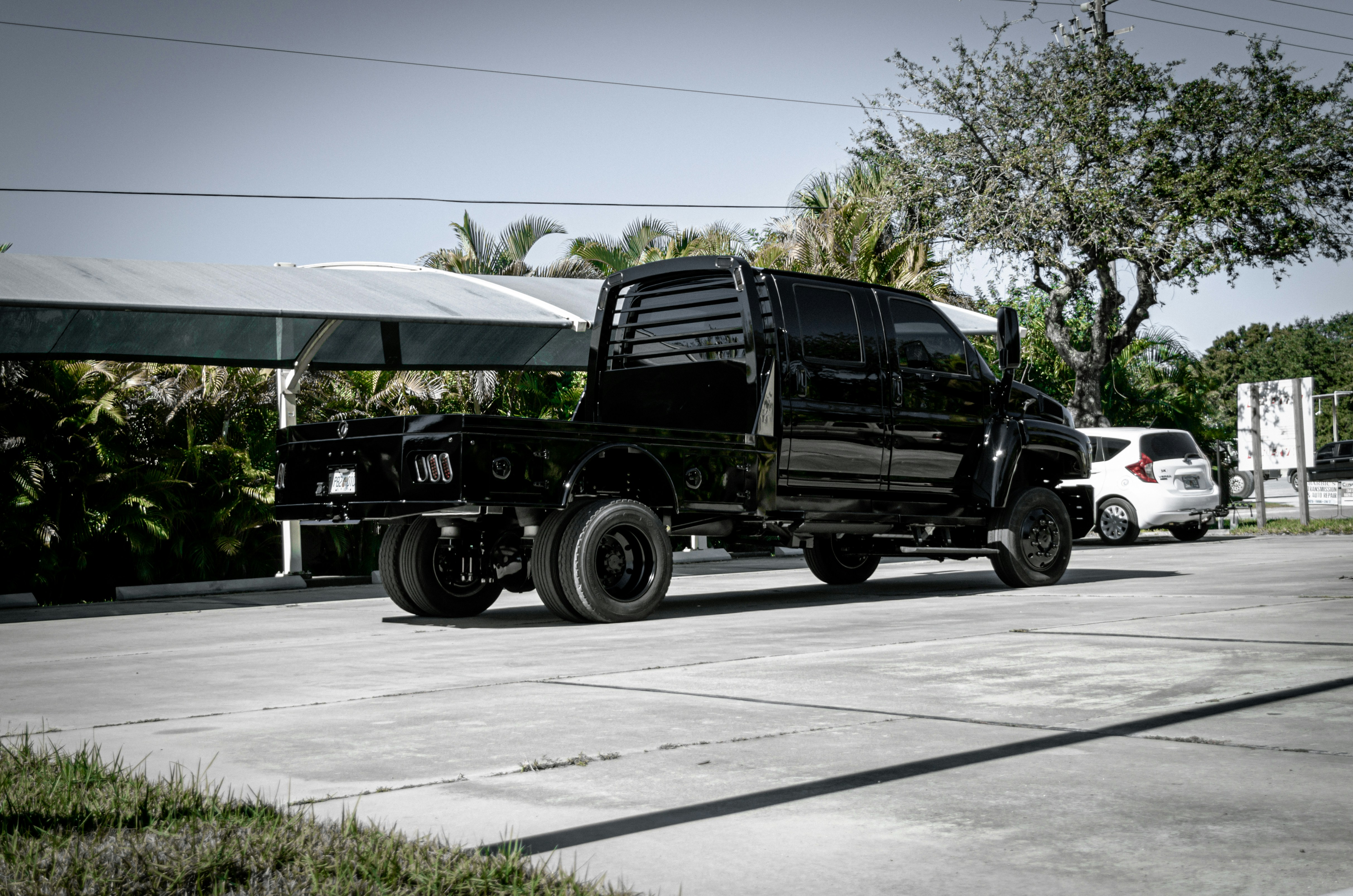 a large black truck parked next to a white car