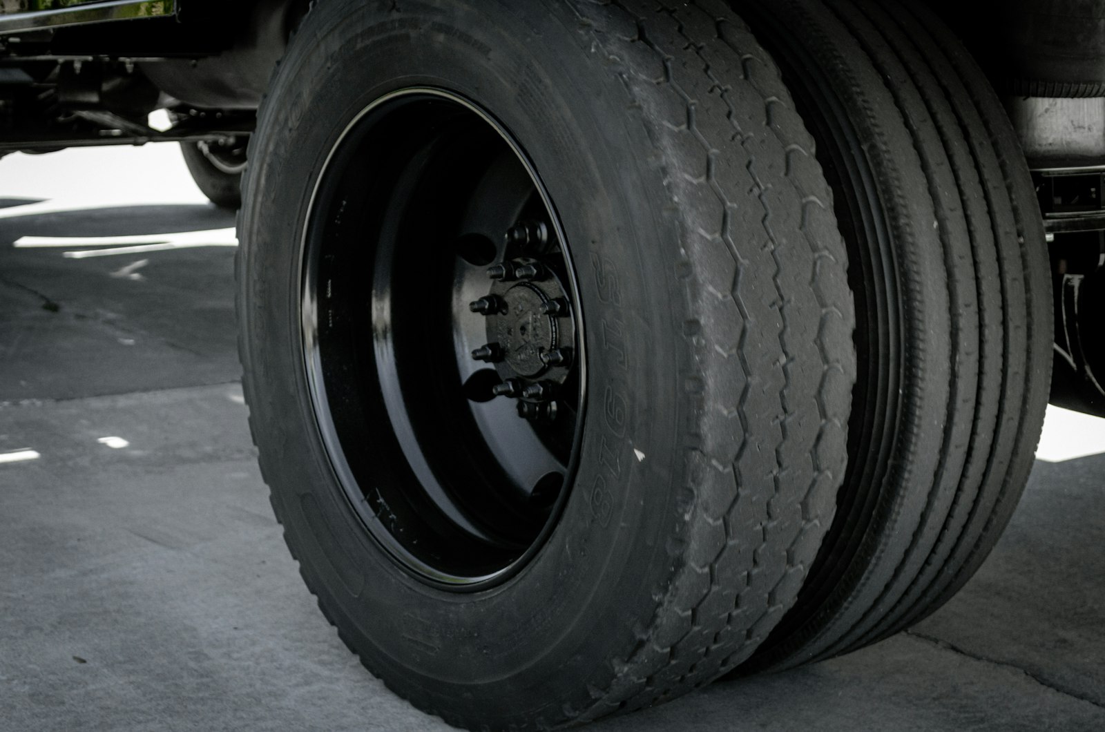Close-up of a commercial truck dual wheel assembly showing the hub, lug nuts and tire that a mobile tire technician services on a road call.