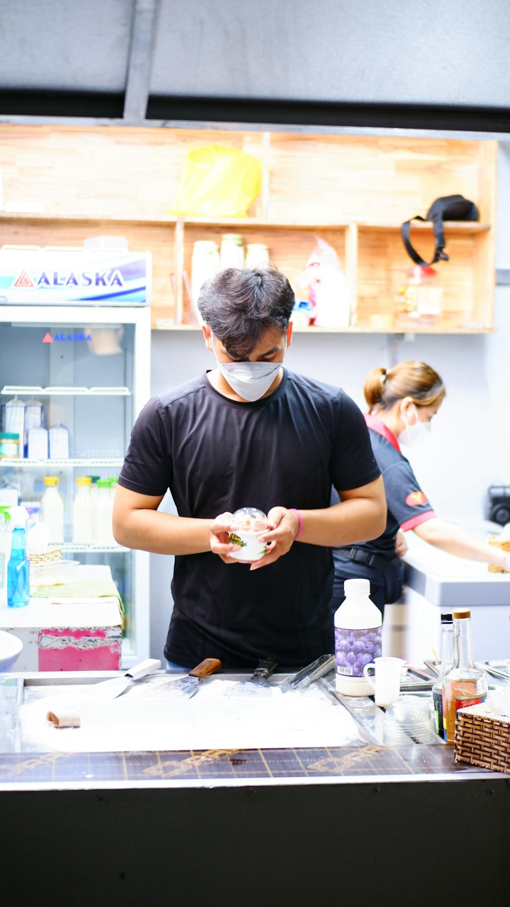a man wearing a face mask preparing food in a kitchen