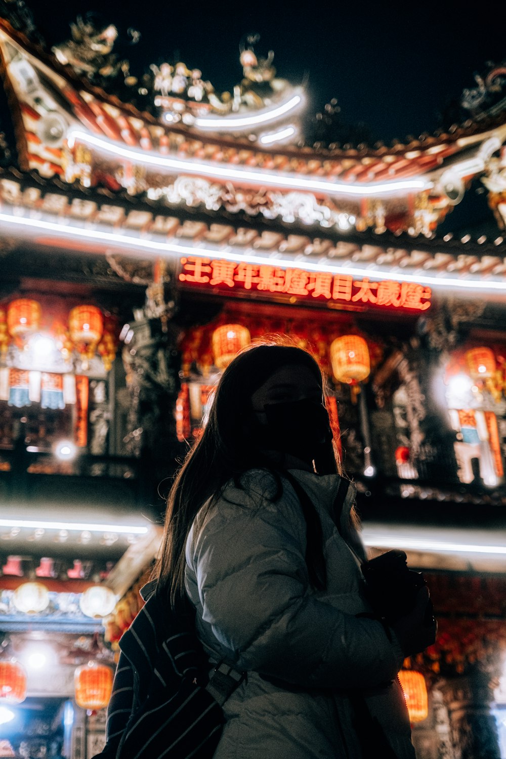 a woman standing in front of a building at night