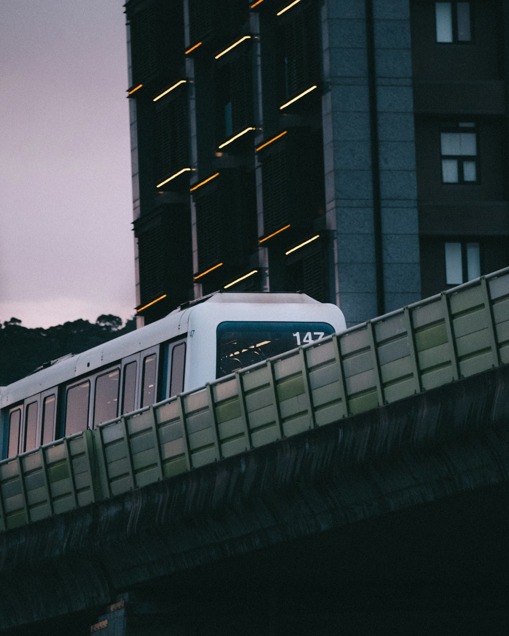 a train traveling over a bridge next to tall buildings