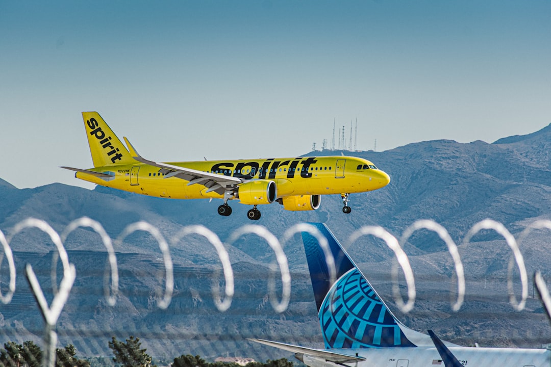a yellow and blue jet airliner taking off from an airport