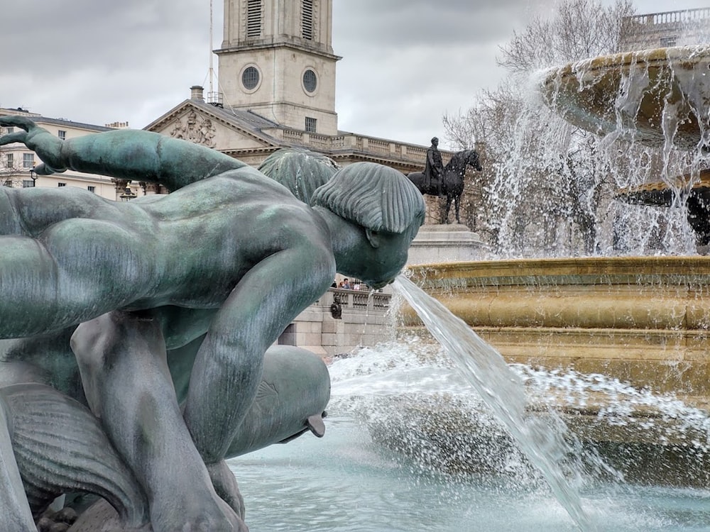 a fountain with a statue in front of a building