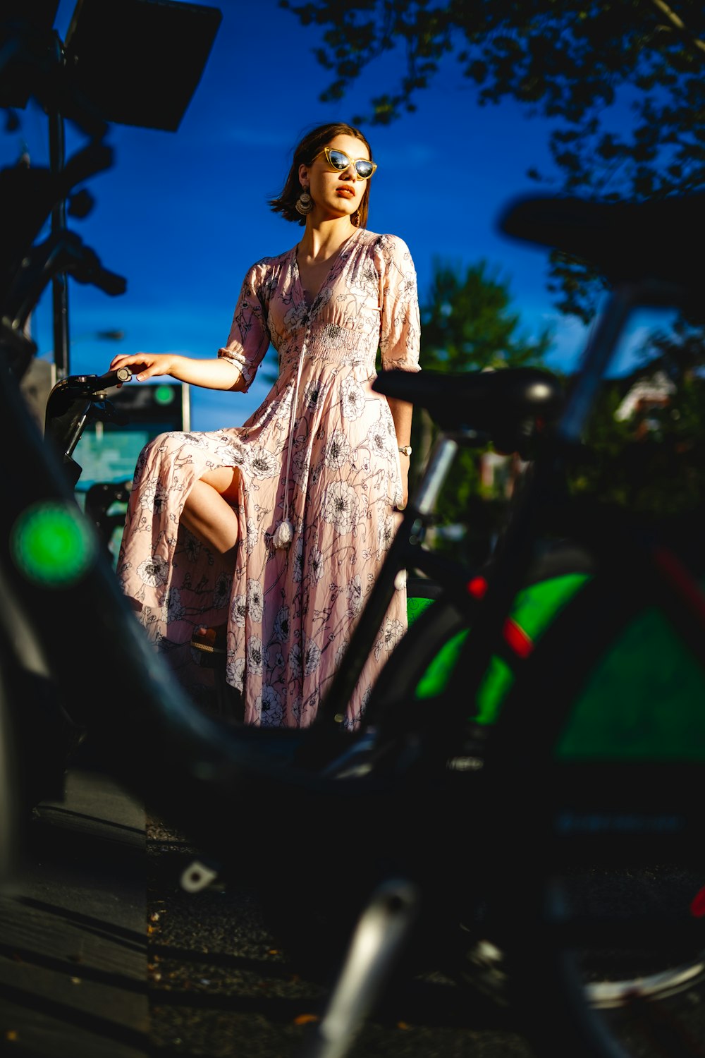 a woman in a pink dress sitting on a bike