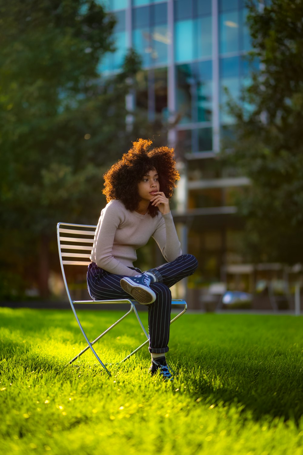 a woman sitting on a chair in the grass