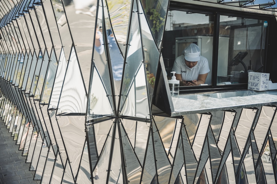 a man standing in a window of a building, 1:39pm - Waiting for our lunch in Alserkal
