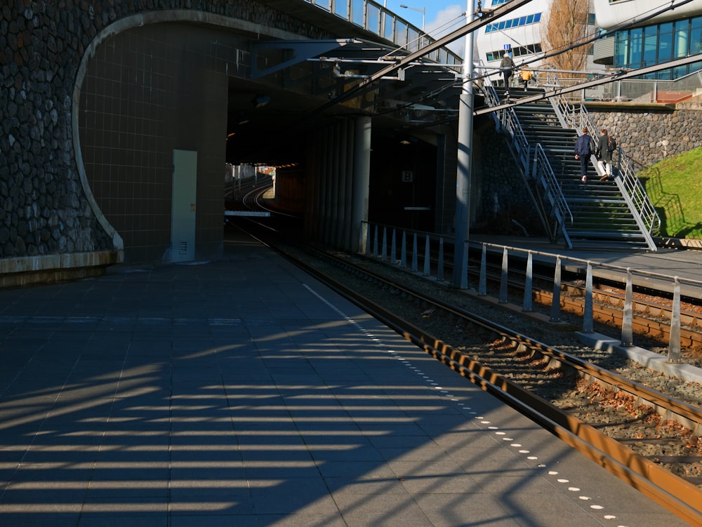 une gare avec un train sortant du tunnel